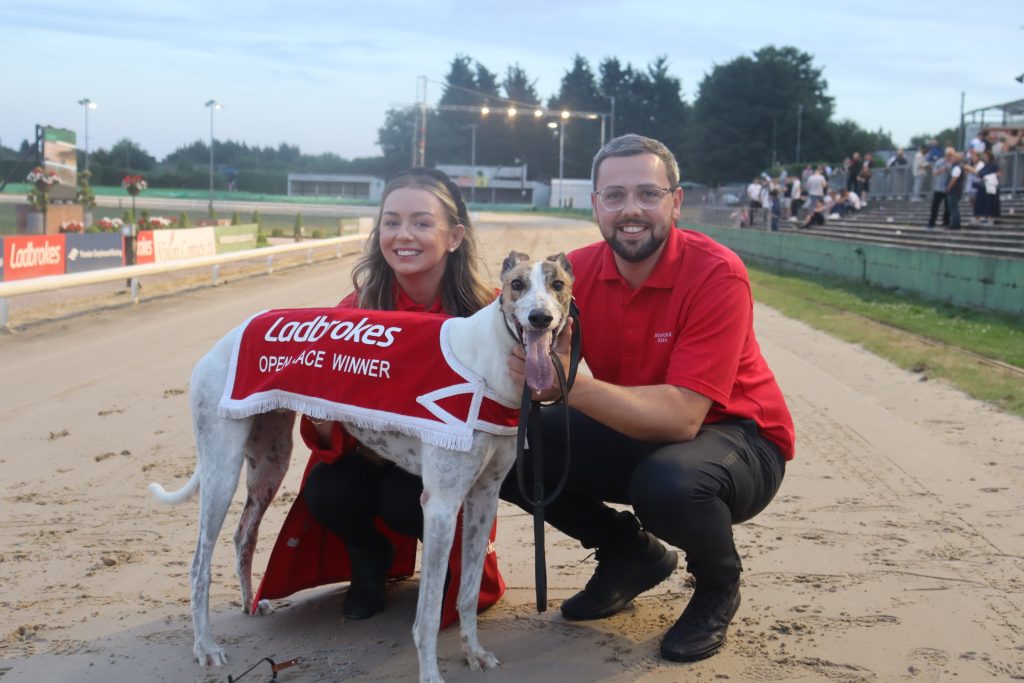 Greyhound trainer, Nathan Hunt and kennel hand Lacie Moran pose for a photo on the Monmore track with Cooladerry Dust