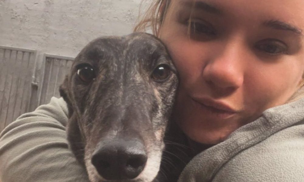Abbey Steels trainer cuddles one of her greyhounds at the Noir Racing Kennels.