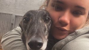 Abbey Steels trainer cuddles one of her greyhounds at the Noir Racing Kennels.
