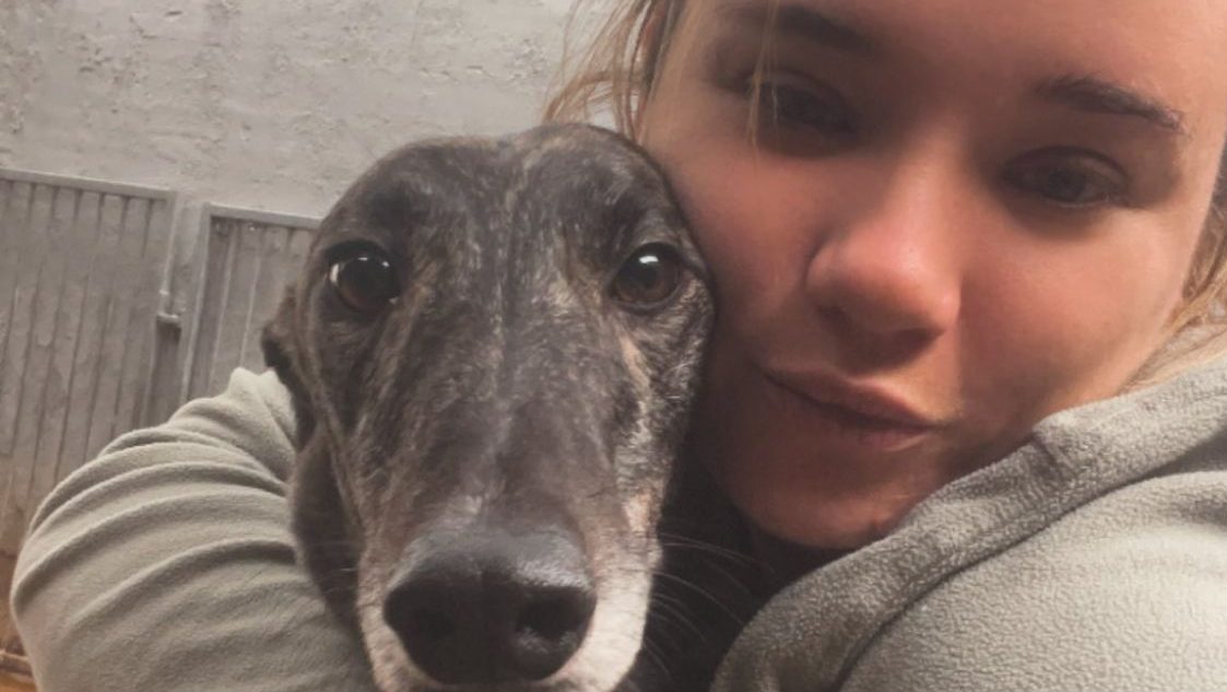 Abbey Steels trainer cuddles one of her greyhounds at the Noir Racing Kennels.